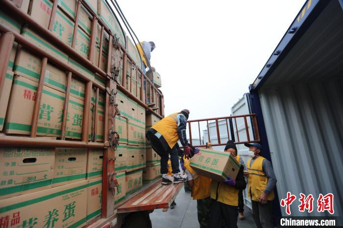 圖為鐵路裝卸作業(yè)人員正在將云南特色農產品裝入集裝箱?！詈?攝
