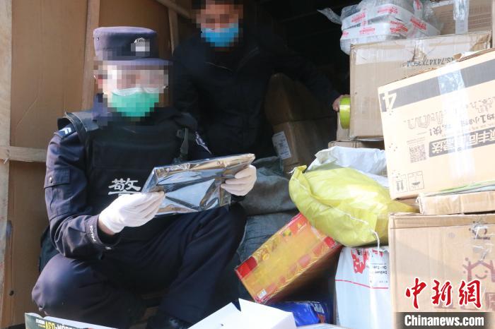 圖為勐康邊檢站民警在對(duì)快遞運(yùn)輸車輛進(jìn)行例行檢查?！钐?攝