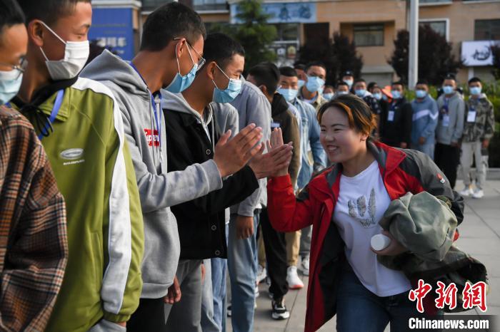 7月7日，拉薩三高考點(diǎn)外，領(lǐng)隊(duì)老師與考生擊掌鼓勁加油?！『闻罾?攝